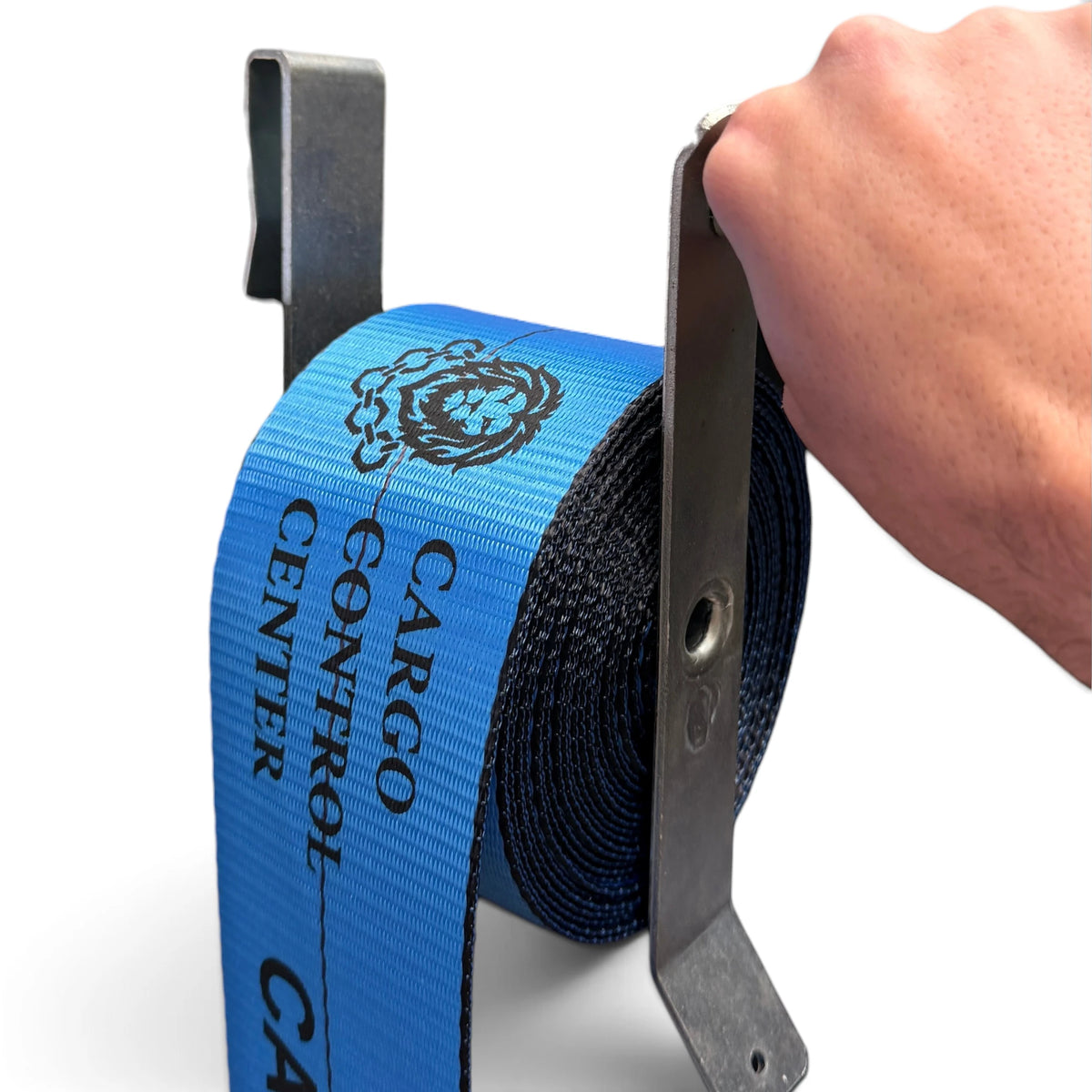 Hand holding the clip-on winder while a blue Cargo Control Center winch strap winds into a coil on it