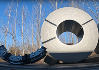 Coil protector segment resting on a trailer deck beside a large steel coil