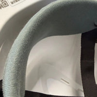 Close-up of the grey fabric brow pad inside the front of the hard hat, next to a black suspension strap.
