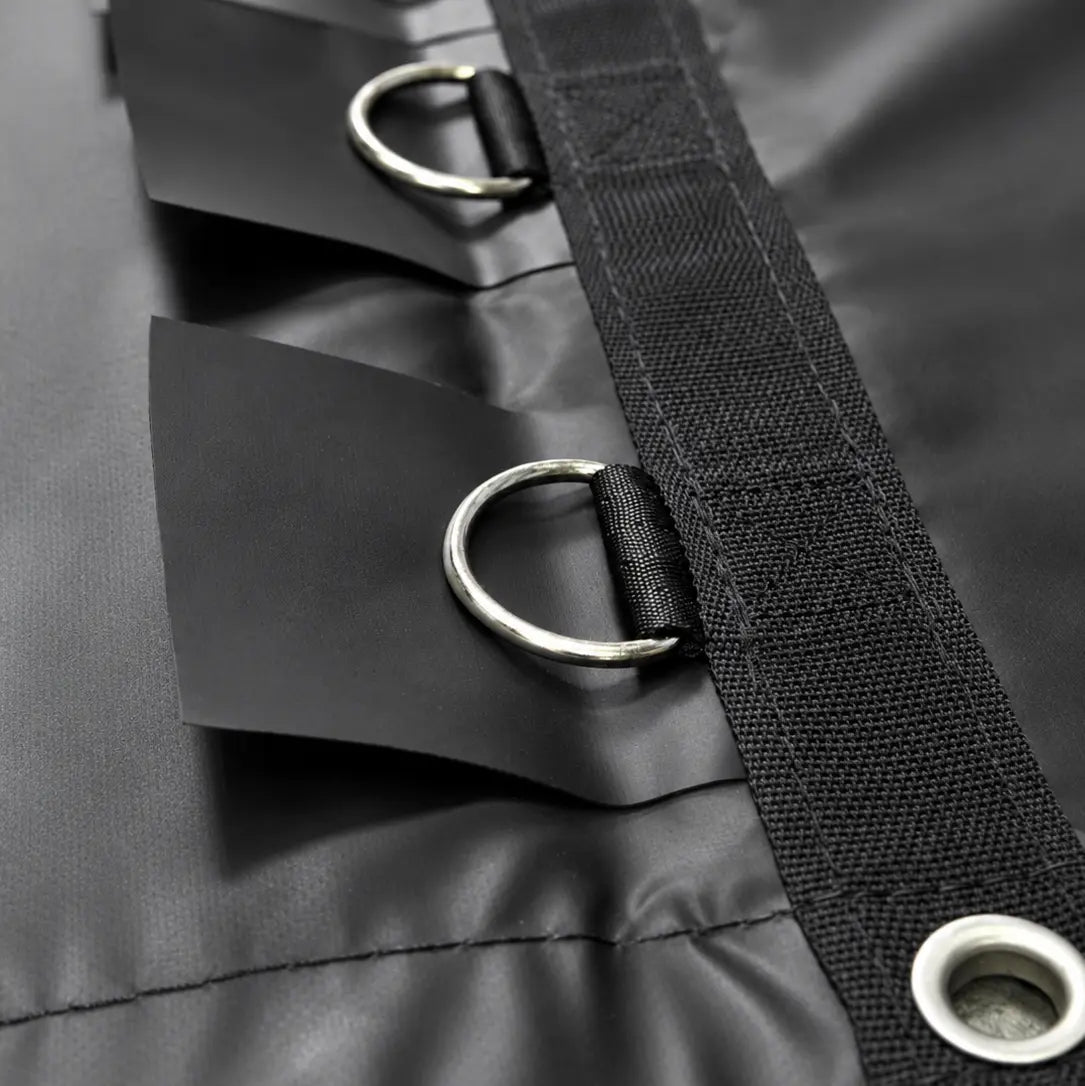 Close-up of the D-ring tie-down loops and grommets stitched along the black vinyl cover