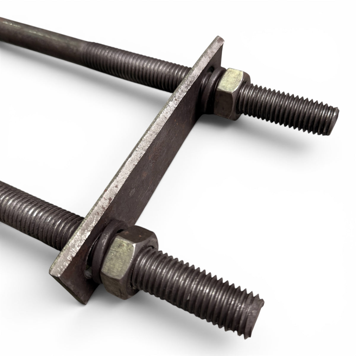 Close-up of one U-bolt's threaded legs, hex nuts and washers holding the flat mounting plate
