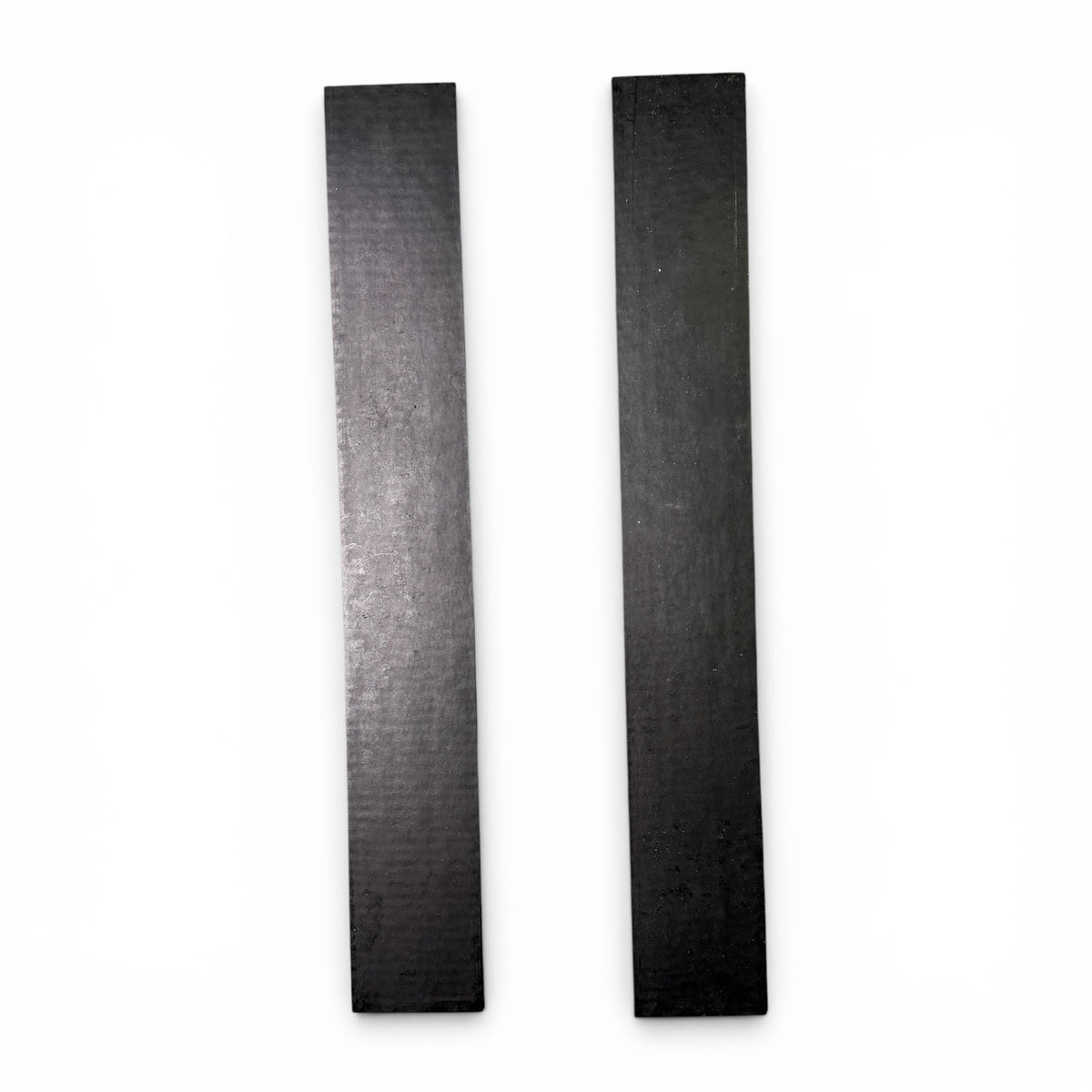 Two black rubber mounting pads laid side by side
