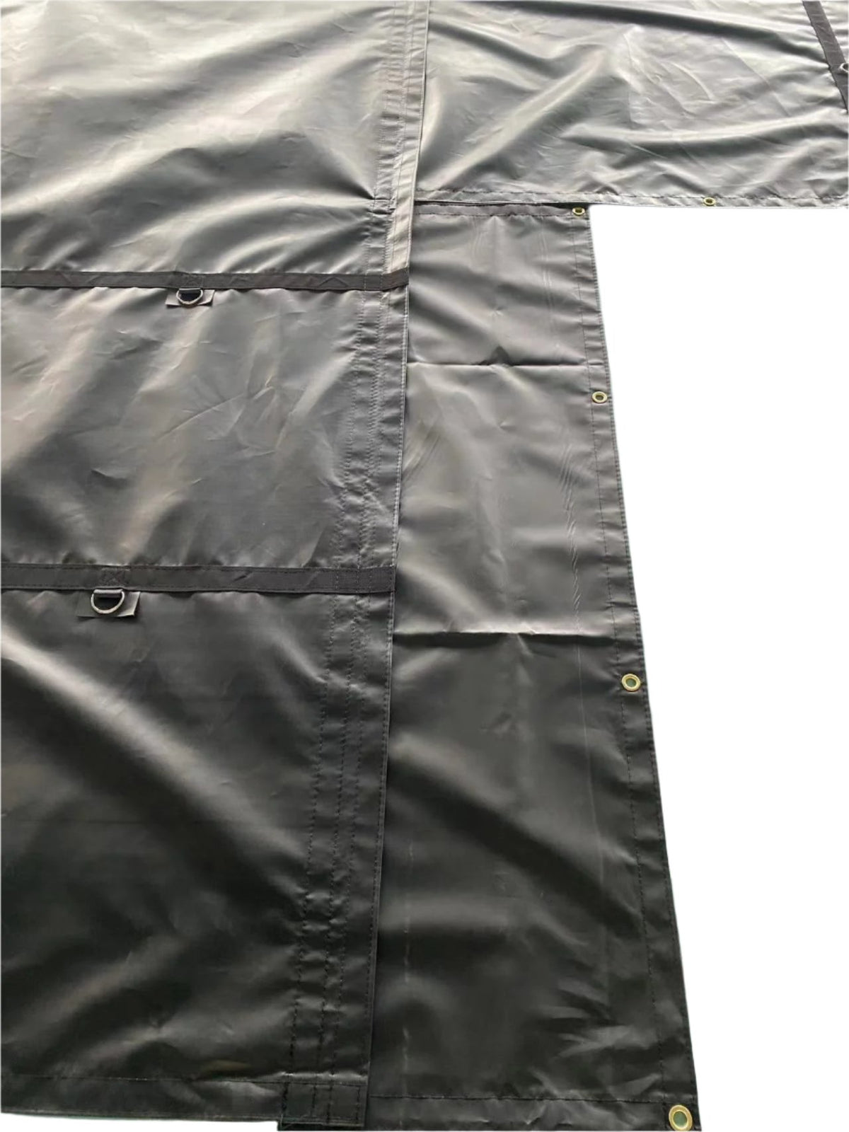 Black tarp's flap corner, showing the L-shaped seam, two D-ring tabs, and edge grommets