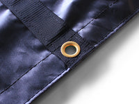 Brass grommet through the end of a black webbing strip at the tarp's double-stitched hem, close up