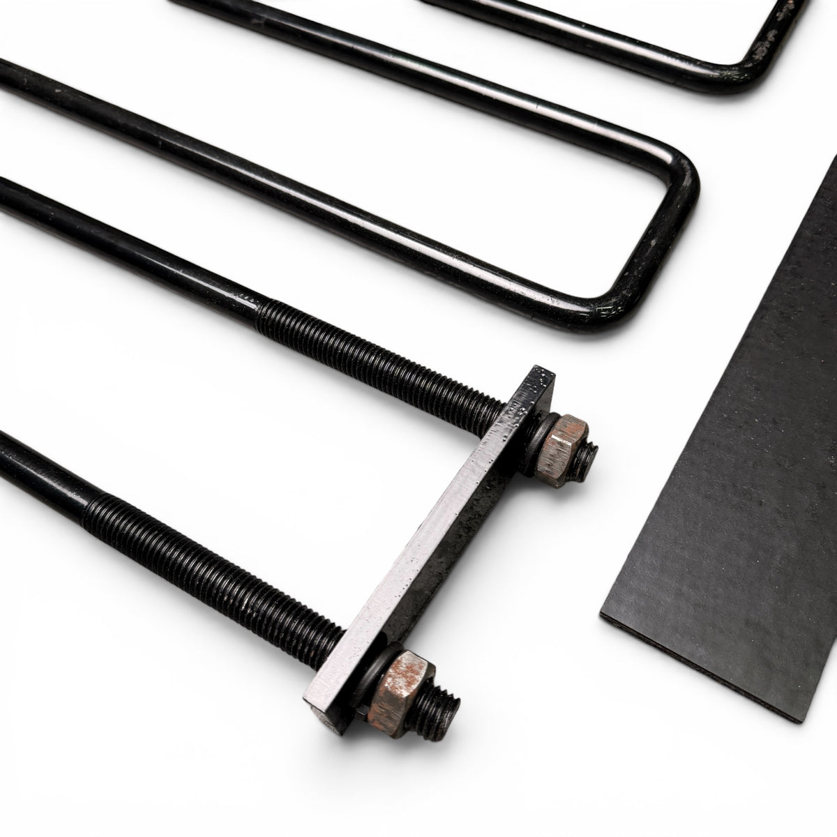 Close-up of the U-bolt threaded ends secured with a mounting plate and nuts