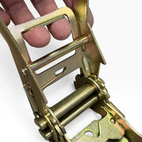 Hand holding the long ratchet handle open, fingers through the wide metal grip frame.