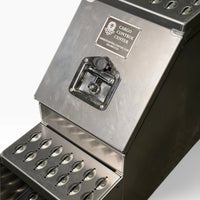 Close-up of the recessed T-handle latch and its lock cover on the saddle tool box door