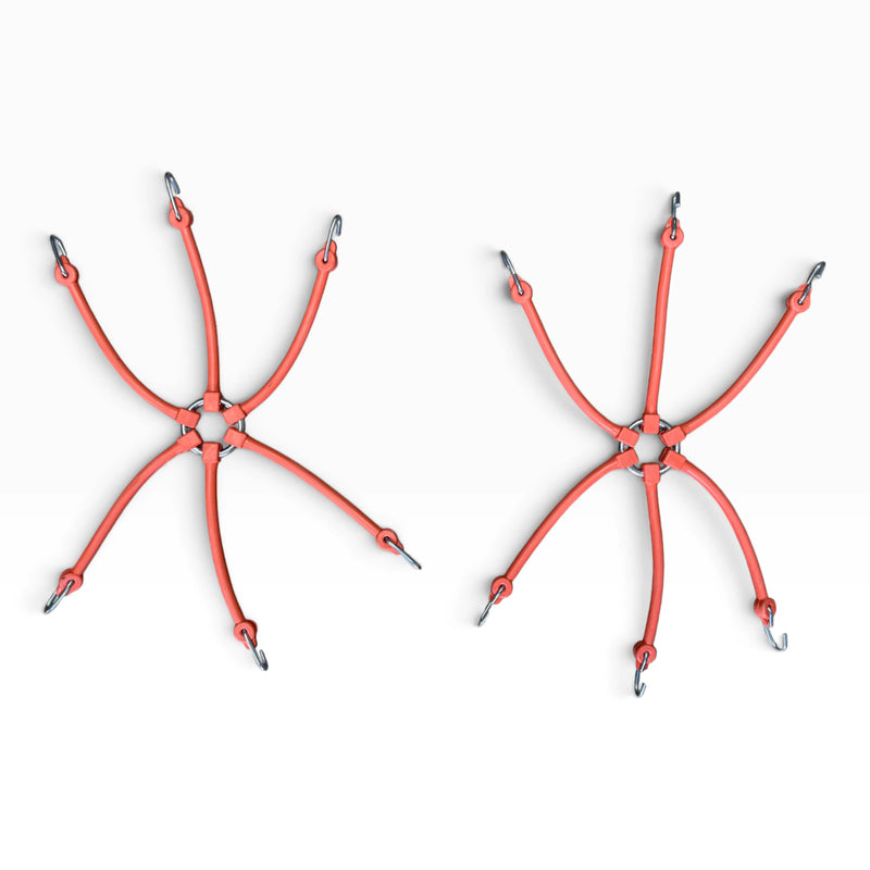 Two orange 6-arm rubber spider bungees laid flat, each arm ending in a steel hook
