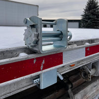 Stake pocket winch installed in a flatbed trailer's stake pocket, outdoors in snow
