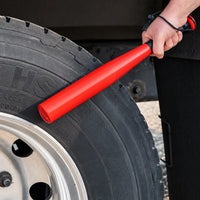 Tire thumper held against the sidewall of a 22.5 inch truck tire, wrist strap around the wrist