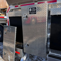 Tool box door installed on a flatbed's headache rack alongside several other diamond-plate compartments