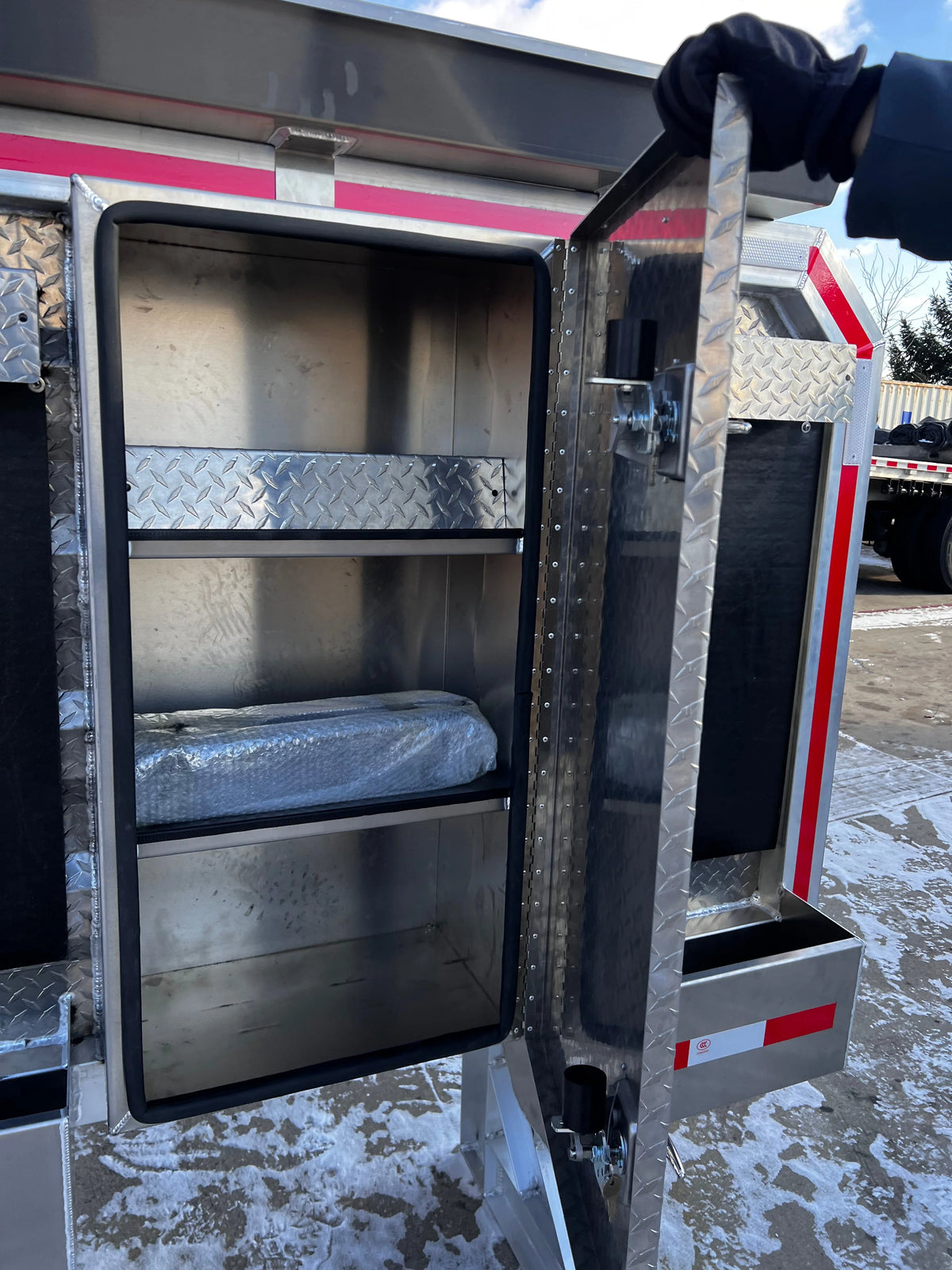 Door swung open showing the empty compartment behind it with two internal shelves