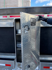 Hand opening the tool box door, showing the compartment and shelves inside