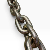 Close-up of the gold zinc-plated chain links with the weld seam visible on each link
